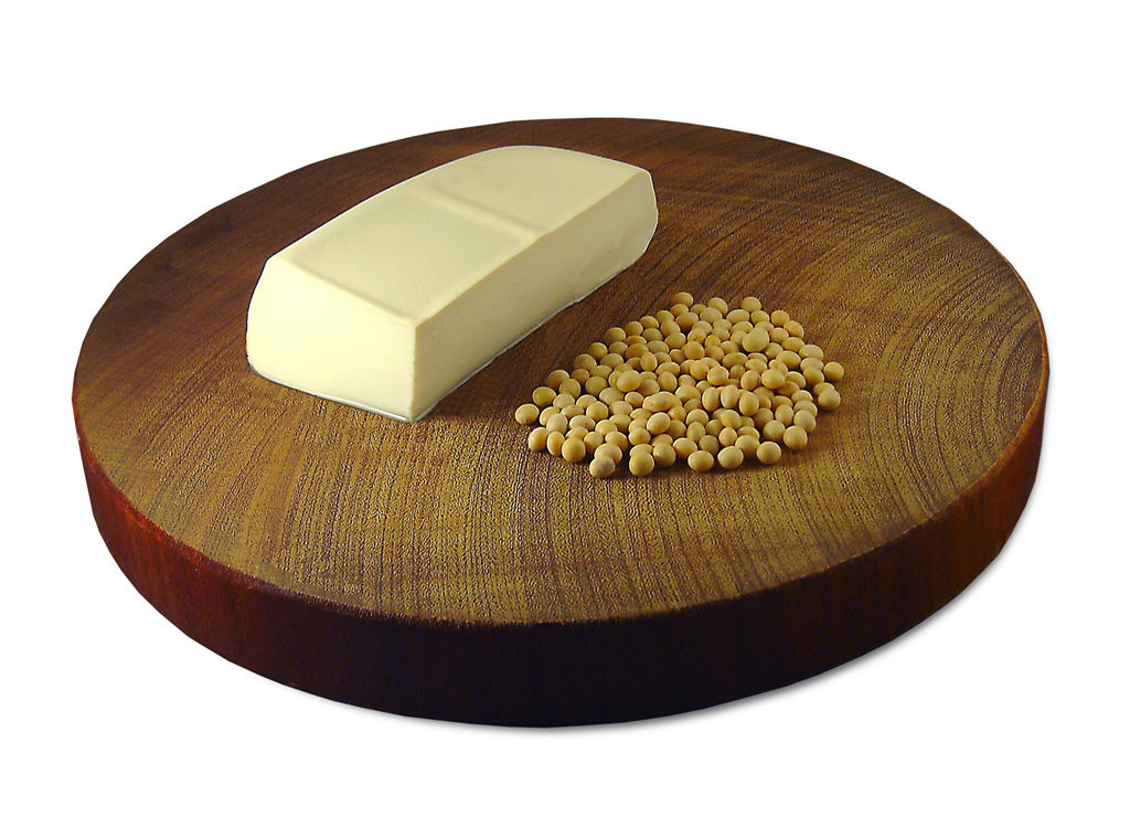 Tofu and soybeans on a wooden cutting board